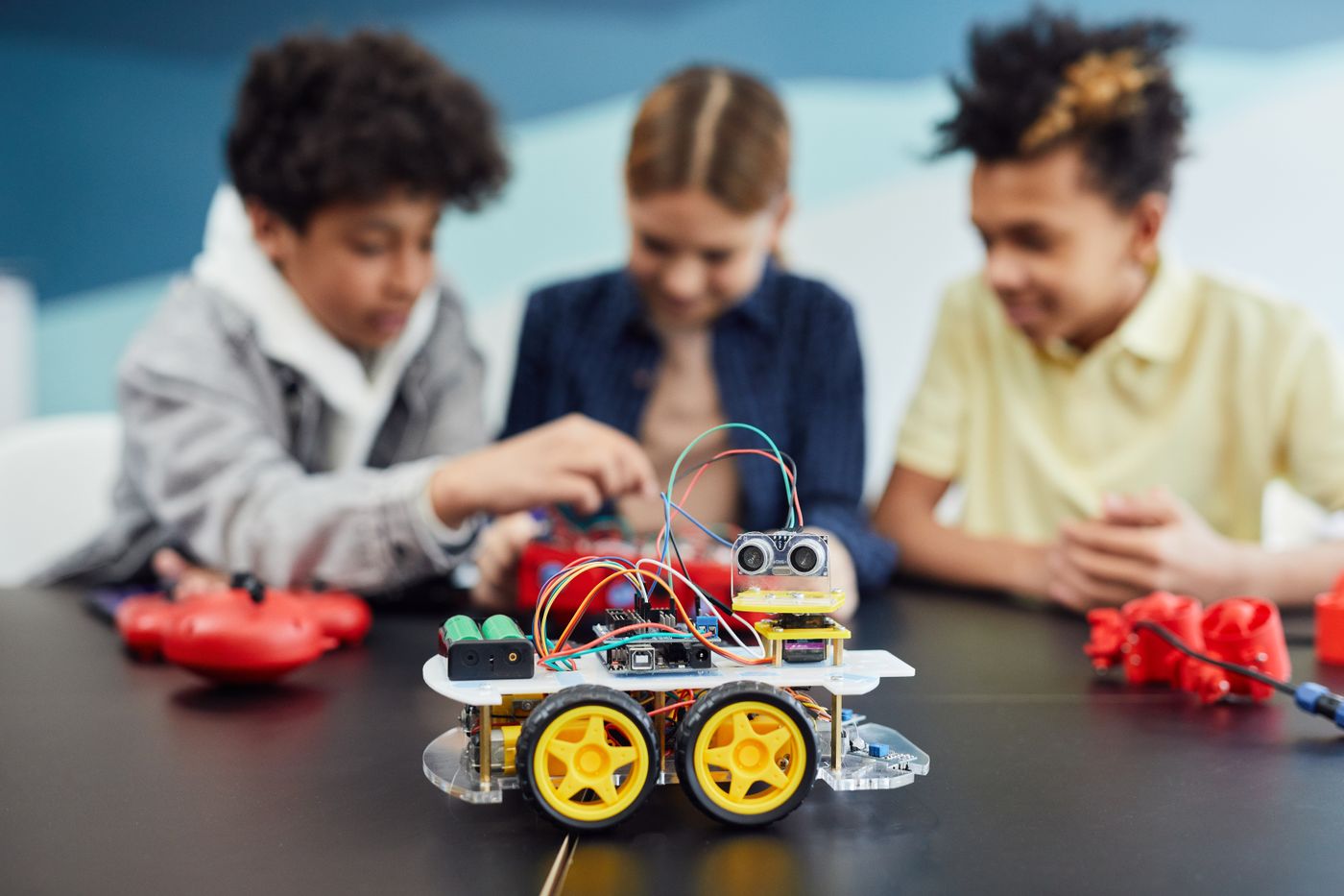 Alumnes construint un robot amb peces LEGO a classe